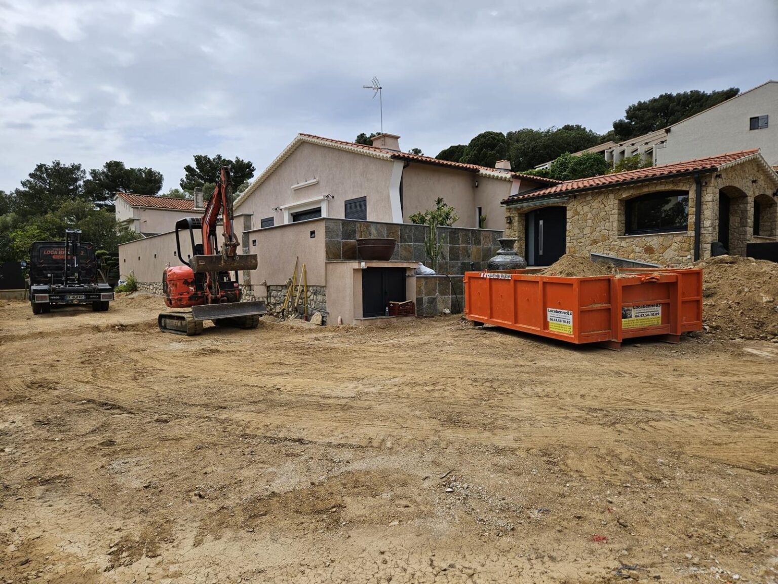 Benne orange Loca Benne 83 sur un chantier de rénovation avec mini-pelle